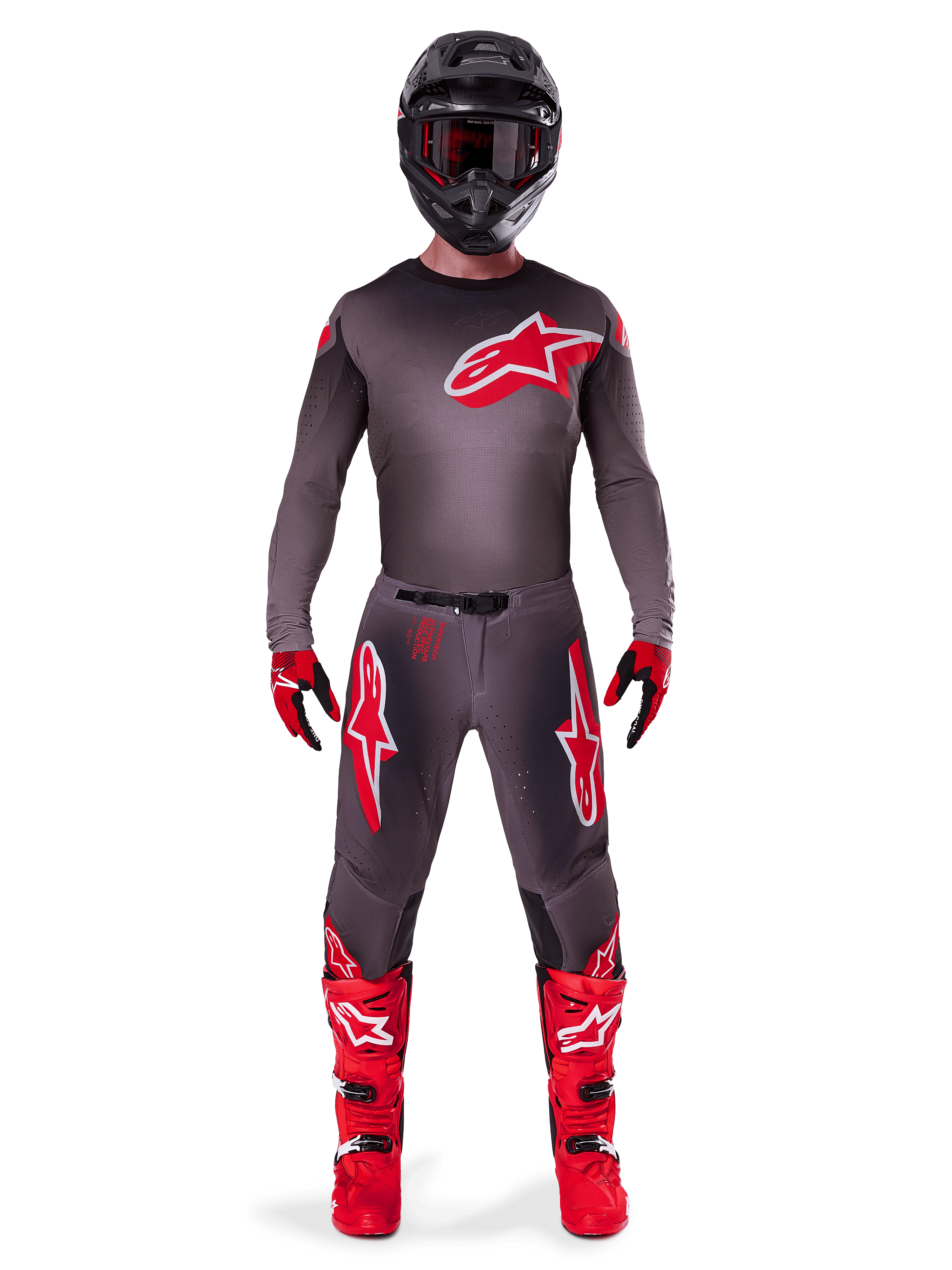 Motocross-Fahrer im kompletten Alpinestars 2025 Supertech Lipan Gear-Set, Smoke Bright Red, mit dunkelgrauem Trikot und Hose mit markanten roten Logos, schwarzem Helm mit Brille, rot-schwarzen Handschuhen und leuchtend roten Motocross-Stiefeln, professionell abgestimmtes Rennoutfit