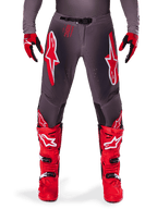 Alpinestars 2025 Supertech Lipan Hose, Motocross-Hose, Smoke Bright Red, graues Design mit markanten roten und weißen Logos, kombiniert mit roten Rennstiefeln und Handschuhen, perforierte Belüftung, Hochleistungs-Offroad-Ausrüstung
