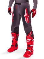 Alpinestars 2025 Supertech Lipan Ausrüstungsset, graue Motocross-Hose mit markanten roten und weißen Stern-Logos, kombiniert mit leuchtend roten Performance-Stiefeln und rot-schwarzen Handschuhen, entwickelt für den Profi-Rennsport