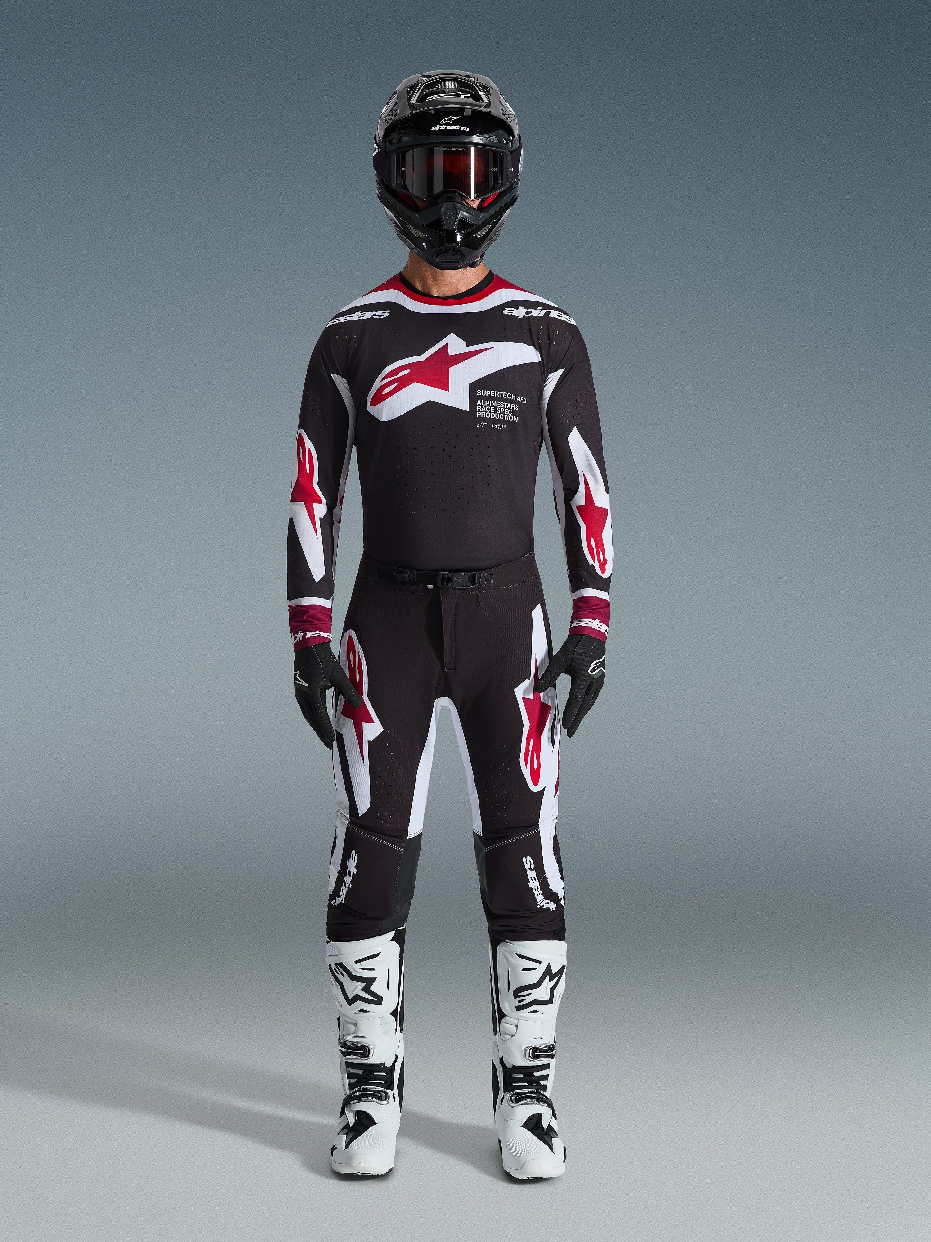 Alpinestars 2026 Supertech AFD Vista Gear Set, Motocross-Rennausrüstung, Schwarz mit roten und weißen Akzenten, komplettes Rennoutfit mit Jersey und Hose im Stern-Logo-Design, schwarzer Helm und weiße Stiefel, professionelle MX-Bekleidung für Offroad-Performance