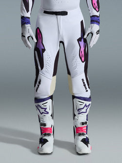 Alpinestars 2026 Supertech AFD Vista Pants, Motocross Pants, White Purple and Black, worn with matching white boots and gloves, featuring pink-to-purple gradient Astars logos on the thighs, professional racing design for off-road performance.