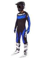 Alpinestars 2025 Techstar Dreem Gear Set, Motocross-Ausrüstung in Schwarz und Blau, inklusive Trikot und Hose mit weißem Branding, getragen mit schwarzem Helm, blau-schwarzen Handschuhen und weiß-schwarzen Stiefeln, komplettes koordiniertes Rennoutfit für Offroad-Performance.