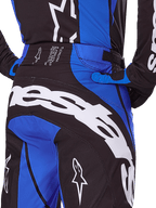 Alpinestars 2025 Techstar Dreem Hose, Motocross-Hose, Schwarz und Blau, Rückansicht mit markantem weißem Branding auf dem Gesäß, blauen Akzenten und Techstar-Bunddetail, kombiniert mit passendem Trikot und Handschuhen