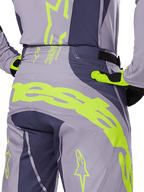 Alpinestars 2025 Techstar Dreem Pants, Motocross Pants, Gray and Dark Gray with bright Lime Green accents, rear detail view showing matching jersey and gloves, large fluorescent yellow branding across the seat, athletic race fit for off-road riding