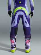 Alpinestars 2026 Supertech Scenz Hose, Motocross-Hose, Lila und Gelb Fluo, Rückansicht mit großem gelben Logo am Gesäß, getragen mit passendem Trikot, Handschuhen und Schutzstiefeln, athletische Passform für professionellen Motocross-Rennsport.
