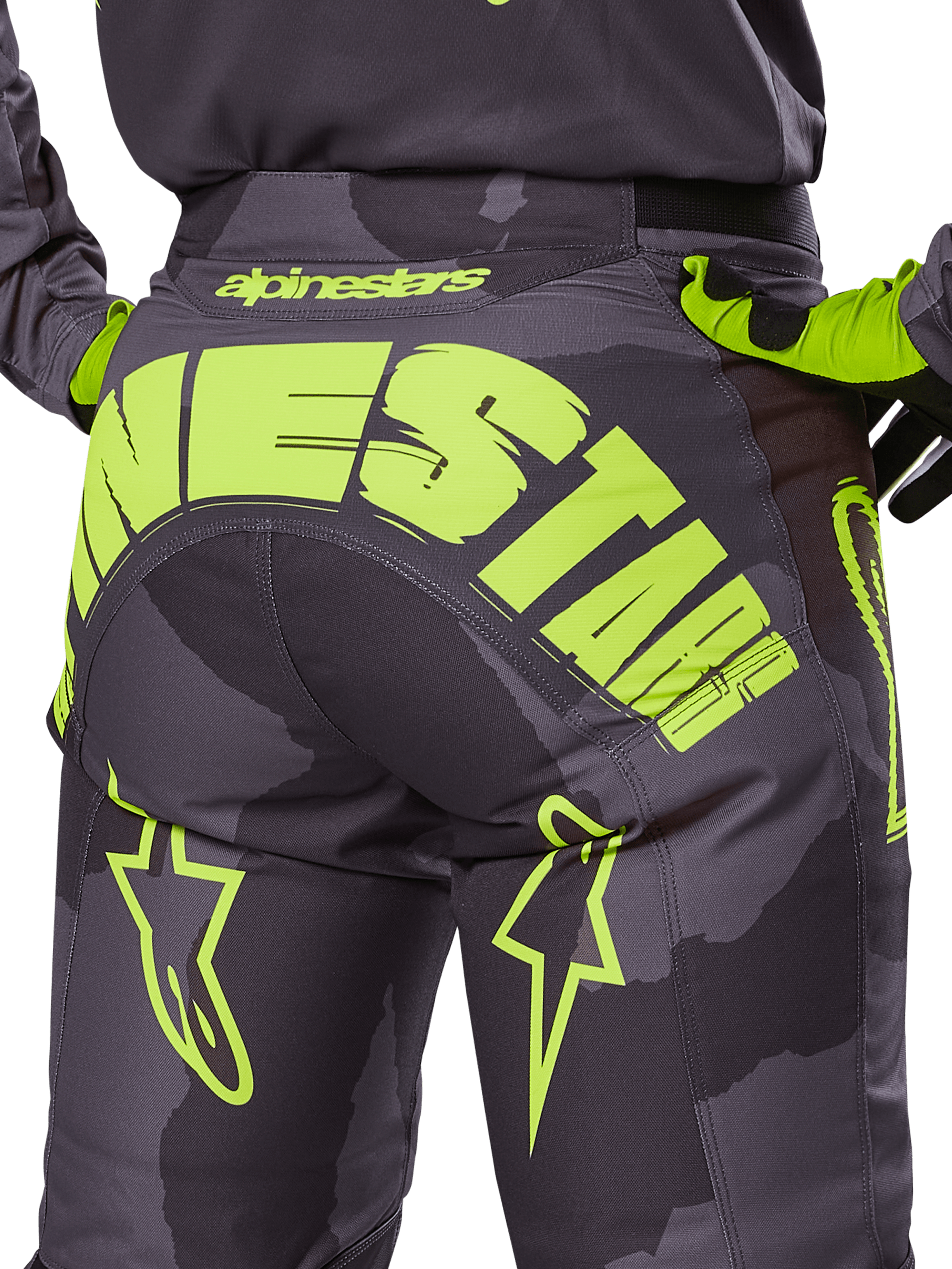 Alpinestars 2025 Racer Hollow Hose, Motocross-Hose, Dark Camo und Yellow Fluo, mit einem großen gelben Alpinestars-Logo auf der Rückseite, taktischem Camouflage-Muster mit leuchtend gelben Akzenten und strapazierfähiger Konstruktion für den Offroad-Rennsport.