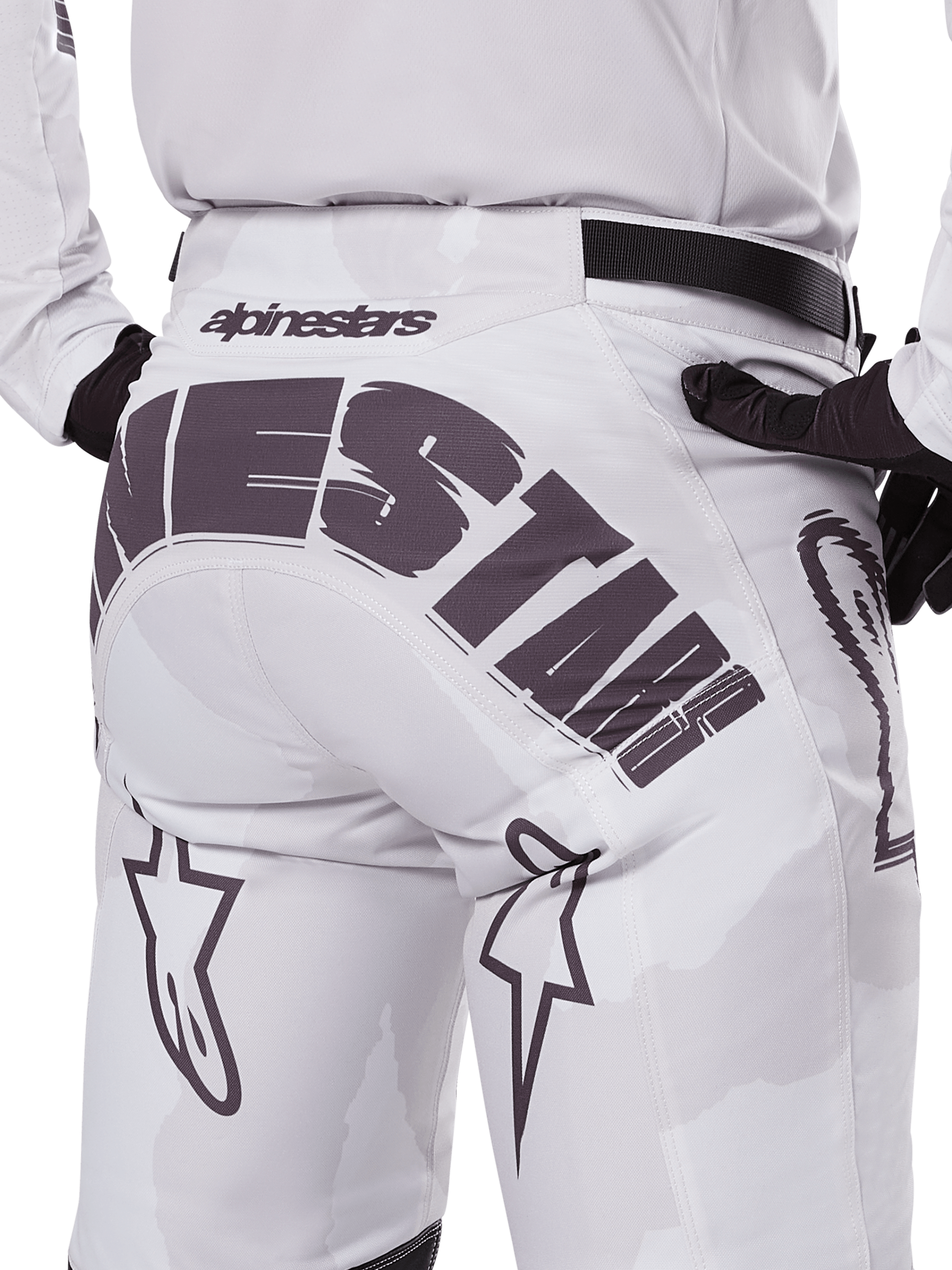 Alpinestars 2025 Racer Hollow Hose, Motocross-Hose, Weiß und Hell-Camo, mit auffälligem schwarzem Alpinestars-Branding am Gesäß, Rückansicht, getragen mit passendem Trikot und schwarzen Handschuhen