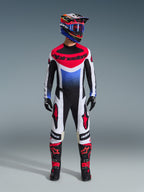 Alpinestars 2026 Techstar Knif Hose, Motocross-Hose, Schwarz, Weiß und Rot, getragen als Teil einer kompletten Rennausrüstung mit passendem Jersey und Helm, mit roten Stern-Logos auf den Oberschenkeln und einer schlanken, athletischen Passform für den Offroad-Rennsport.