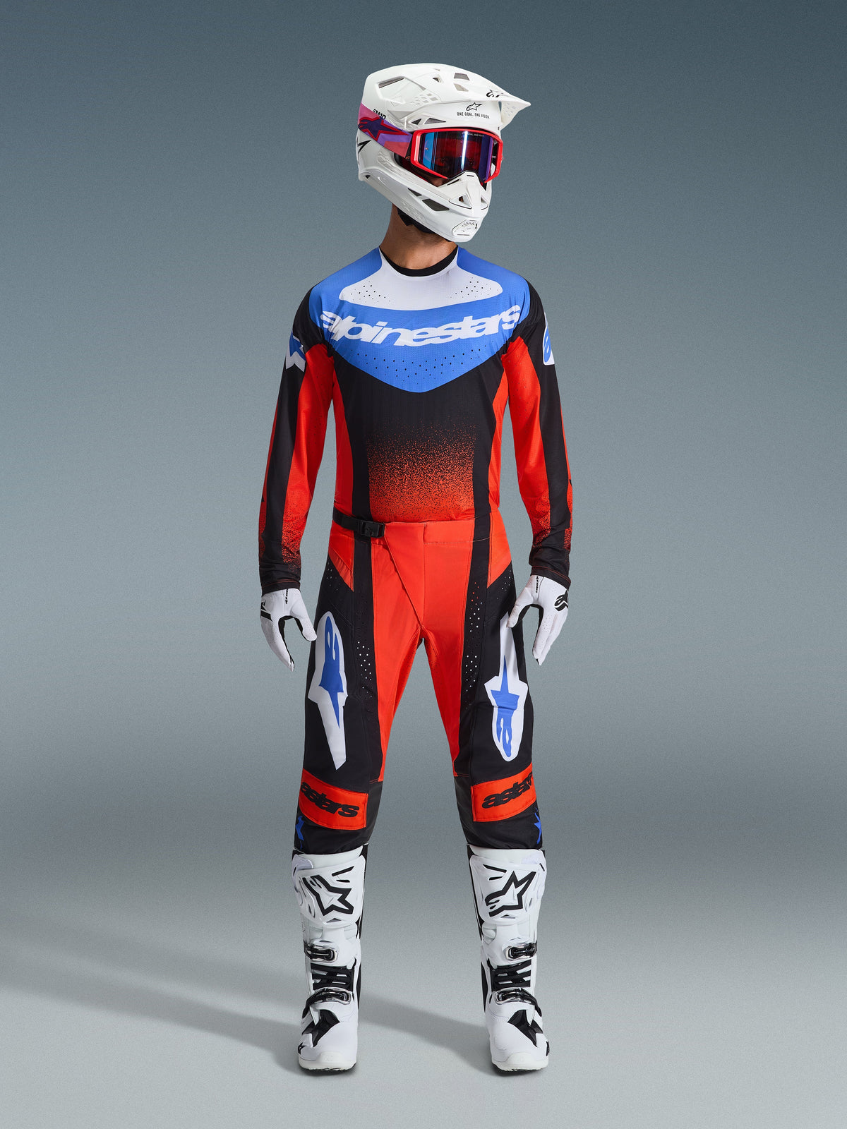 Alpinestars 2026 Techstar Knif Gear Set, Motocross-Rennausrüstung, Rot und Schwarz mit blauen Akzenten, komplettes MX-Outfit inklusive Jersey, Hose, weißem Helm mit pinken und blauen Grafiken, weißen Handschuhen und weißen Stiefeln, professionelle Offroad-Rennausrüstung