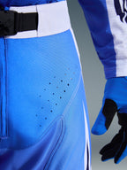 Alpinestars 2026 Techstar Knif Pants, Ucla Blue and White, close-up of hip area showing laser-cut perforations for ventilation, SX2 magnetic buckle waist closure, and matching motocross gloves