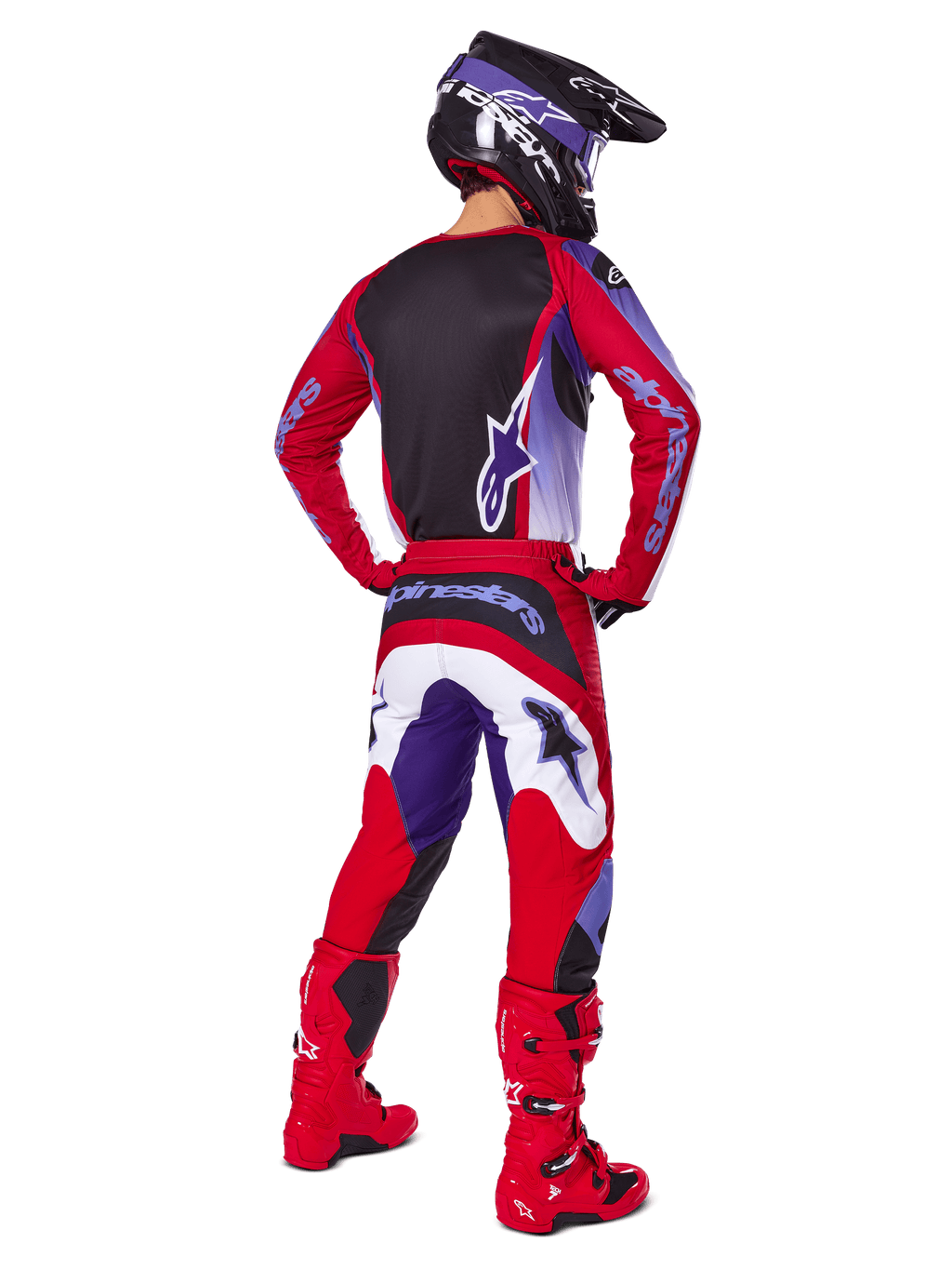 Motocross-Fahrer von hinten in Alpinestars 2025 Fluid Wurx Hose, Purple Bright Red mit weißen und schwarzen Akzenten, passendes Trikot, schwarzer Helm und rote Stiefel, abgestimmtes Outfit für den Offroad-Rennsport