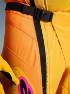 Alpinestars 2026 Techstar Nomur Hose, Motocross-Hose, Orange, Gelb, Pink, Nahaufnahme des Taillenbereichs mit dem SX2-Magnetverschluss, schwarzem Verstellriemen und lasergeschnittenen Belüftungsperforationen auf strapazierfähigem Ripstop-Material