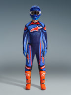 Alpinestars 2026 Techstar Nomur Gear-Set, Motocross-Fahrer in voller Rennausrüstung, Dunkelblau mit orangefarbenen und UCLA-blauen Akzenten, passendes Trikot und Hose mit großen Logos, blauer Helm und leuchtend orangefarbene Stiefel, abgestimmte Offroad-Wettkampfausrüstung.