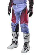Alpinestars 2024 Racer Hoen Hose, Motocross-Hose, Lavan-Lila und Schwarz mit roten Grafiken, rote Stern-Logos auf den Oberschenkeln und schwarzer Schriftzug an den Knien, getragen mit weiß-schwarzen Stiefeln und schwarzen Handschuhen