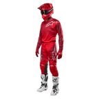 Motocross-Fahrer in kompletter Rennausrüstung, Alpinestars 2024 Racer Hoen Hose und Trikot in Mars Red Burgundy, roter Helm, rote Handschuhe und weiß-schwarze Stiefel, abgestimmtes Outfit für Offroad-Rennen