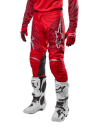 Alpinestars 2024 Racer Hoen Hose, Motocross-Hose, Mars Red und Burgundy, getragen mit passendem rotem Trikot und Handschuhen sowie weißen Stiefeln, mit schwarzen Leder-Kniepaneelen und weißen Logos, strapazierfähige technische Ausrüstung für Offroad-Rennsport