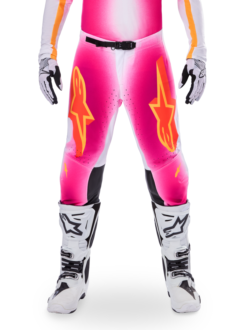Alpinestars Limited Edition Supertech AFD MIG Hose, Motocross-Rennhose, Pink Fluo und Weiß mit orangen Akzenten, mit großen Stern-Logos auf den Oberschenkeln, perforierten Einsätzen und schwarzen Knie-Grip-Zonen, getragen mit weiß-schwarzen Motocross-Stiefeln