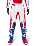 Limited Edition Techstar Fortitude Pants, Motocross Pants, Bright Red White and Blue, worn with matching gear including blue protective boots and gloves, featuring white chassis with red graphics, black leather knee panels, and laser-cut perforations, professional off-road racing apparel