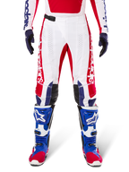Limited Edition Techstar Fortitude Pants, Motocross Pants, Bright Red White and Blue, worn with matching gear including blue protective boots and gloves, featuring white chassis with red graphics, black leather knee panels, and laser-cut perforations, professional off-road racing apparel
