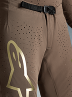 Alpinestars Supertech Air Gold Hose Limited Edition, braune Motocross-Hose mit SX1 Magnetverschluss und goldenem Logo.