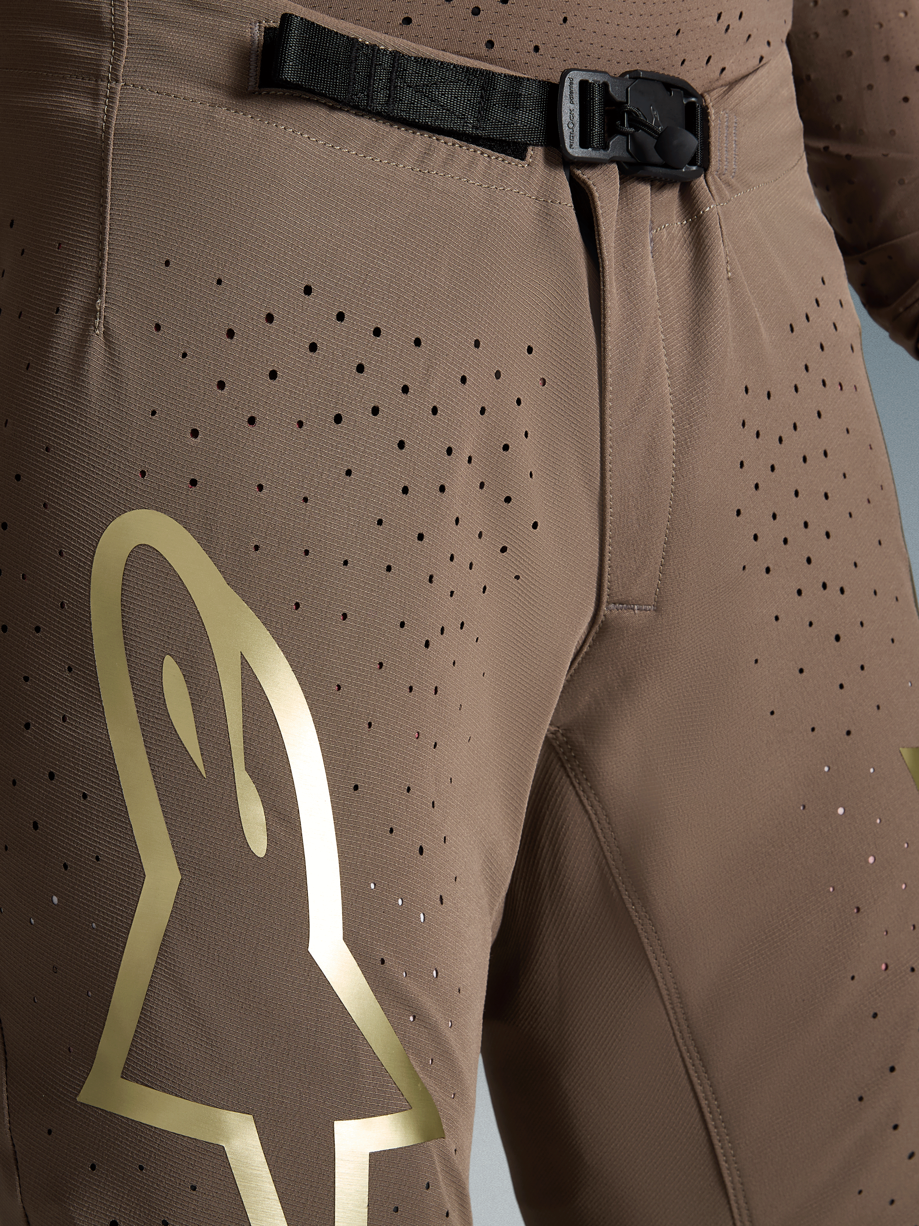 Alpinestars Supertech Air Gold Hose Limited Edition, braune Motocross-Hose mit SX1 Magnetverschluss und goldenem Logo.