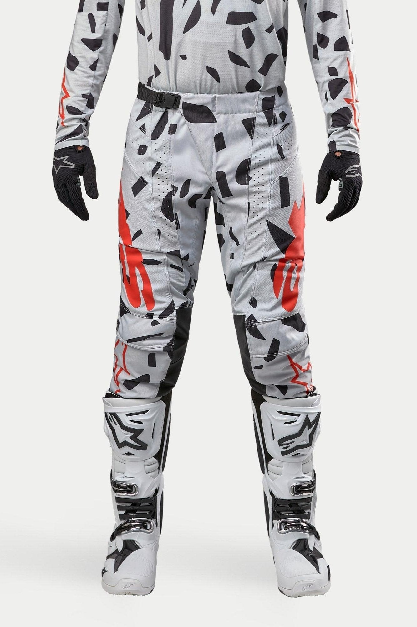 Alpinestars 2024 Techstar Rantera Hose, Motocross-Hose, Haze Gray Camo, getragen mit passendem Jersey, schwarzen Handschuhen und weißen Stiefeln, mit schwarzem Punktmuster und rotem Alpinestars-Branding, strapazierfähiges Design für den Offroad-Rennsport