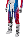 Alpinestars 2024 Techstar Pneuma Hose, Motocross-Rennsport-Hose, Blu Mars Rot Weiß, getragen mit passendem Trikot, weißen Rennstiefeln und Handschuhen, lebhaftes Grafikdesign mit roten, blauen und lila Akzenten, perforiert für Atmungsaktivität