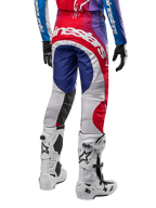 Alpinestars 2024 Techstar Pneuma Hose, Motocross-Hose, Blu Mars Rot Weiß, Rückansicht getragen mit passendem Trikot und weißen Stiefeln, auffälliges weißes Branding auf dem Gesäß, mehrfarbige Einsätze, professionelle Motocross-Rennausrüstung