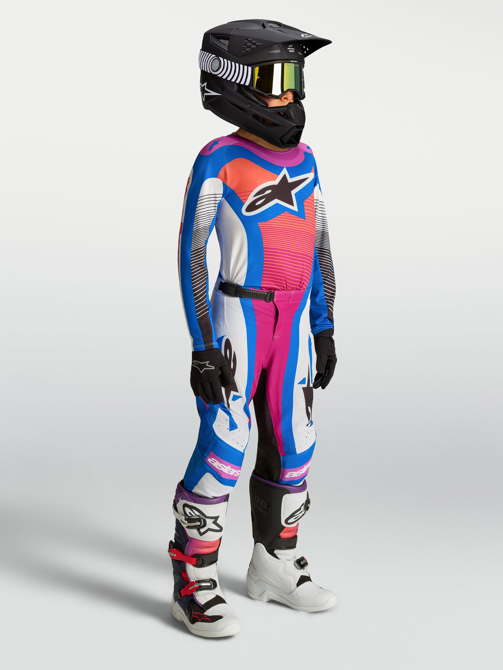 Alpinestars Jugend Supertech Maven Hose, Motocross-Rennhose für junge Fahrer, Weiß, Blau und Korallpink, athletische Passform mit 4-Wege-Stretch, getragen von einem Model mit Helm und Stiefeln, für Motocross und Offroad