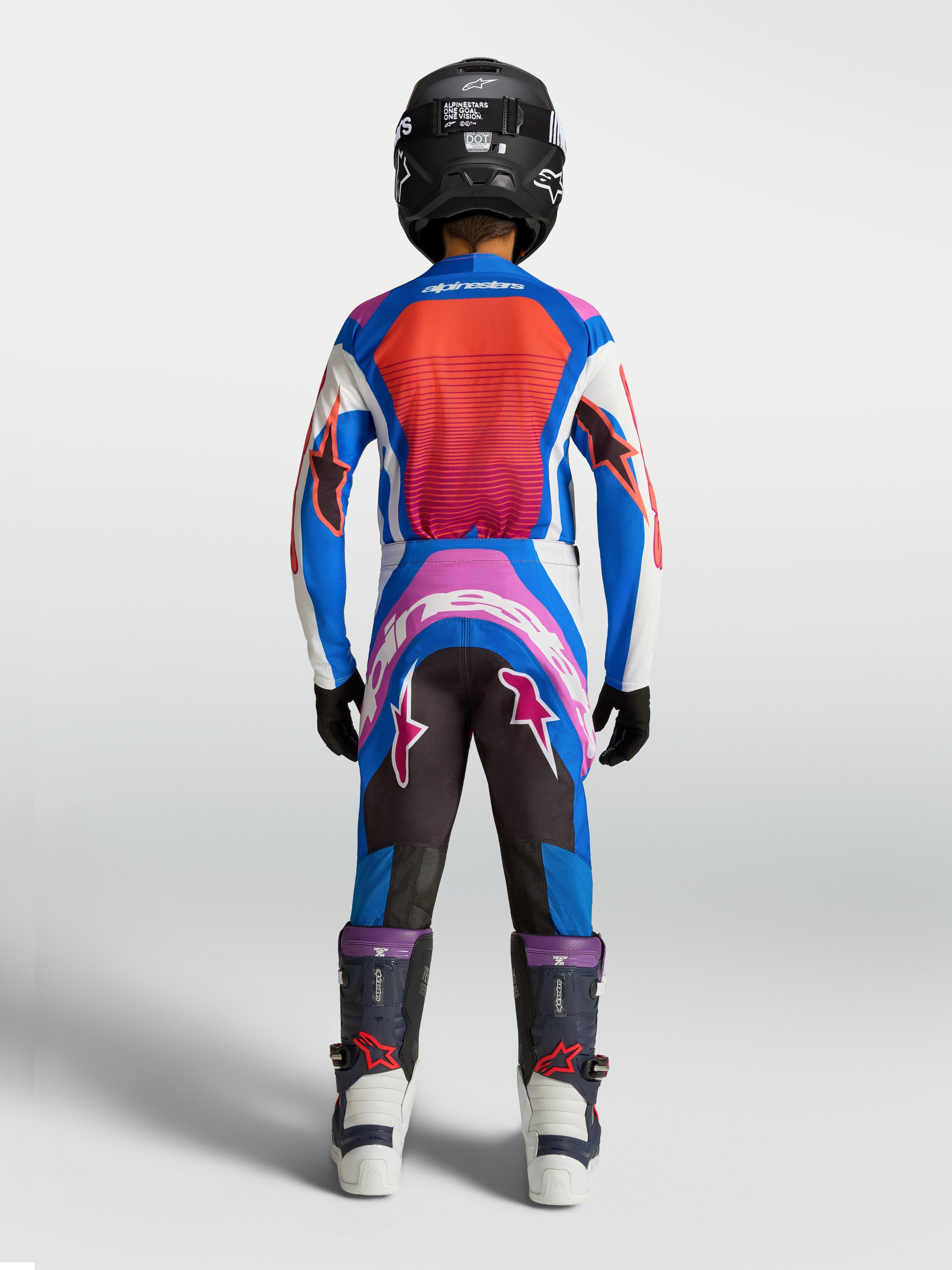 Alpinestars Jugend Supertech Maven Hose, Motocross-Hose in Blau und Hot Coral, athletische Rennpassform, Rückansicht eines jungen Fahrers.
