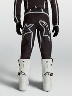 Alpinestars Youth Fluid Apex V2 Pants, black and silver motocross racing gear with ergonomic rear fit and star logos.
