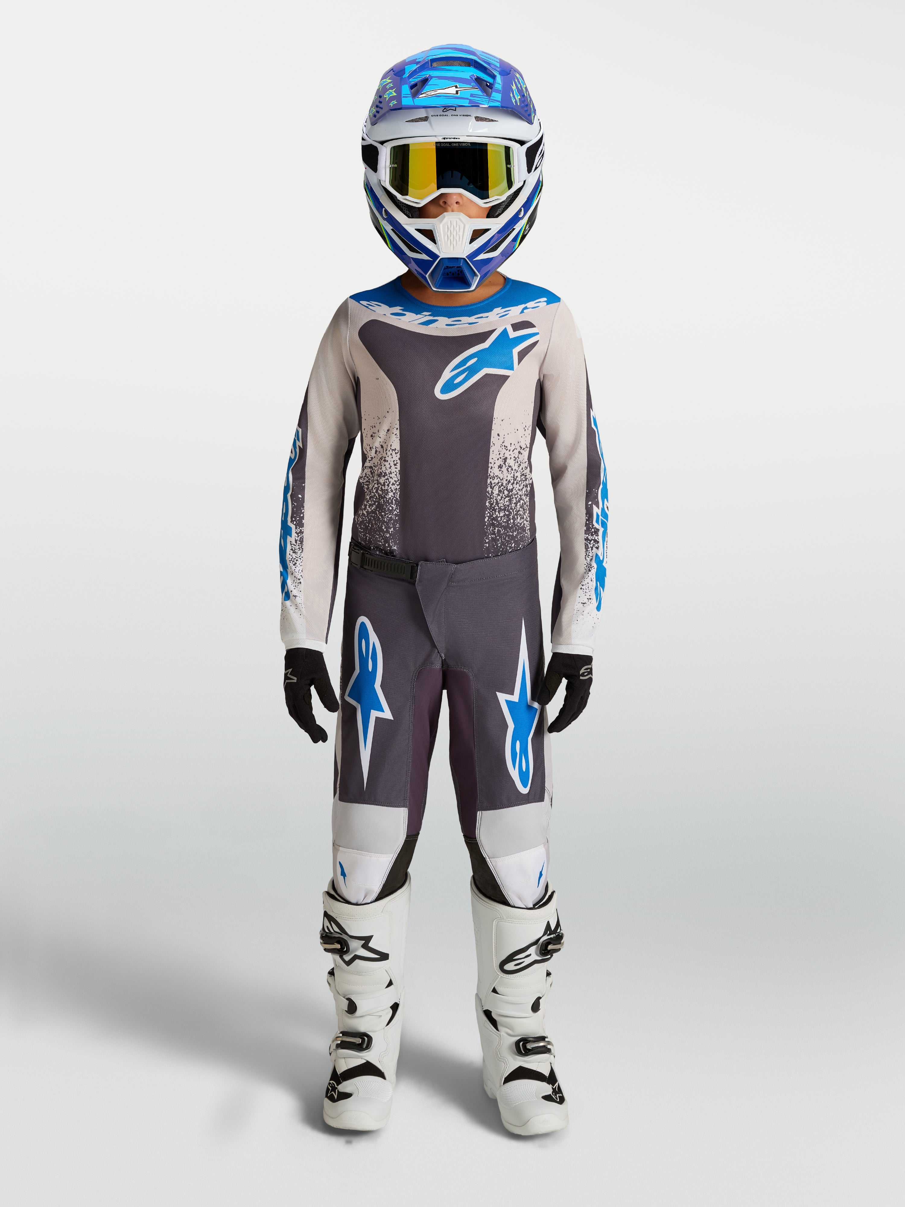 Alpinestars Fluid Drag Jugend-Hose, Motocross-Ausrüstung, Grau und Blau, Polygewebe, weiße Motorradstiefel.