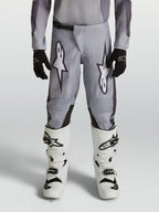 Alpinestars Youth Fluid Amber Pants, durable grey and black motocross pants for young riders in an off-road setting.