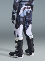 Alpinestars 2026 Youth Fluid Lahnd Pants, Motocross Pants, Iron Camo with white accents, rear view showing 'astars' branding on the seat, worn with matching camo jersey and black and white Tech 3 motocross boots.