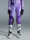 Alpinestars 2026 Stella Fluid Apex Damen-Hose, Motocross-Hose, Violett und Weiß, kombiniert mit schwarz-violetten Handschuhen und weiß-schwarzen Stiefeln, mit markantem weißem Branding am Bein, ergonomisches Sport-Fit-Design für Offroad-Rennsport
