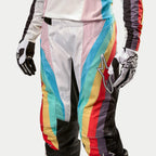 Alpinestars Damen Stella 2024 Techstar Hose, Motocross-Hose, Schwarz Mehrfarbig mit leuchtenden diagonalen Streifen in Blau, Rosa, Gelb und Rot, mit einem großen Stern-Logo auf dem Oberschenkel, kombiniert mit passendem Trikot und Handschuhen, professionelle Offroad-Rennausrüstung