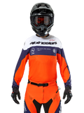 Alpinestars Pro-Dura Jersey, Motocross-Trikot, Marineblau, Hot Orange und Weiß, getragen mit schwarzem Helm und Handschuhen, mit laserperforierten Belüftungszonen, auffälligem Branding und „ONE GOAL. ONE VISION.“ Grafik auf der Brust