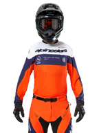 Alpinestars Pro-Dura Jersey, Motocross-Trikot, Marineblau, Hot Orange und Weiß, getragen mit schwarzem Helm und Handschuhen, mit laserperforierten Belüftungszonen, auffälligem Branding und „ONE GOAL. ONE VISION.“ Grafik auf der Brust