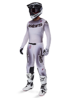 Motocross-Fahrer im Alpinestars 2025 Supertech Maker Trikot in Silber und Schwarz, passende silber-schwarze Hose, schwarz-weißer Helm mit schwarzer Brille, weiß-schwarze Stiefel und koordinierte Handschuhe, professionelles Farbverlauf-Design für den Offroad-Rennsport