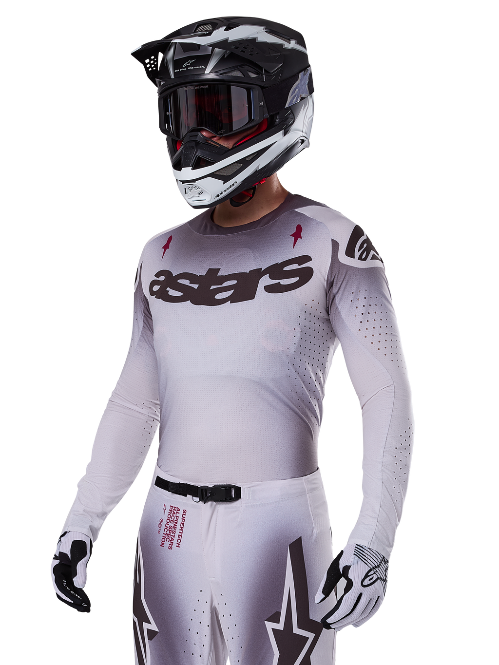 Alpinestars 2025 Supertech Maker Jersey, Motocross-Renntrikot, Silber-Schwarz-Farbverlauf, atmungsaktives Stretch-Mesh mit lasergeschnittenen Perforationen, getragen mit passender Hose und Helm, mit „astars“-Branding, komplette professionelle Offroad-Ausrüstung