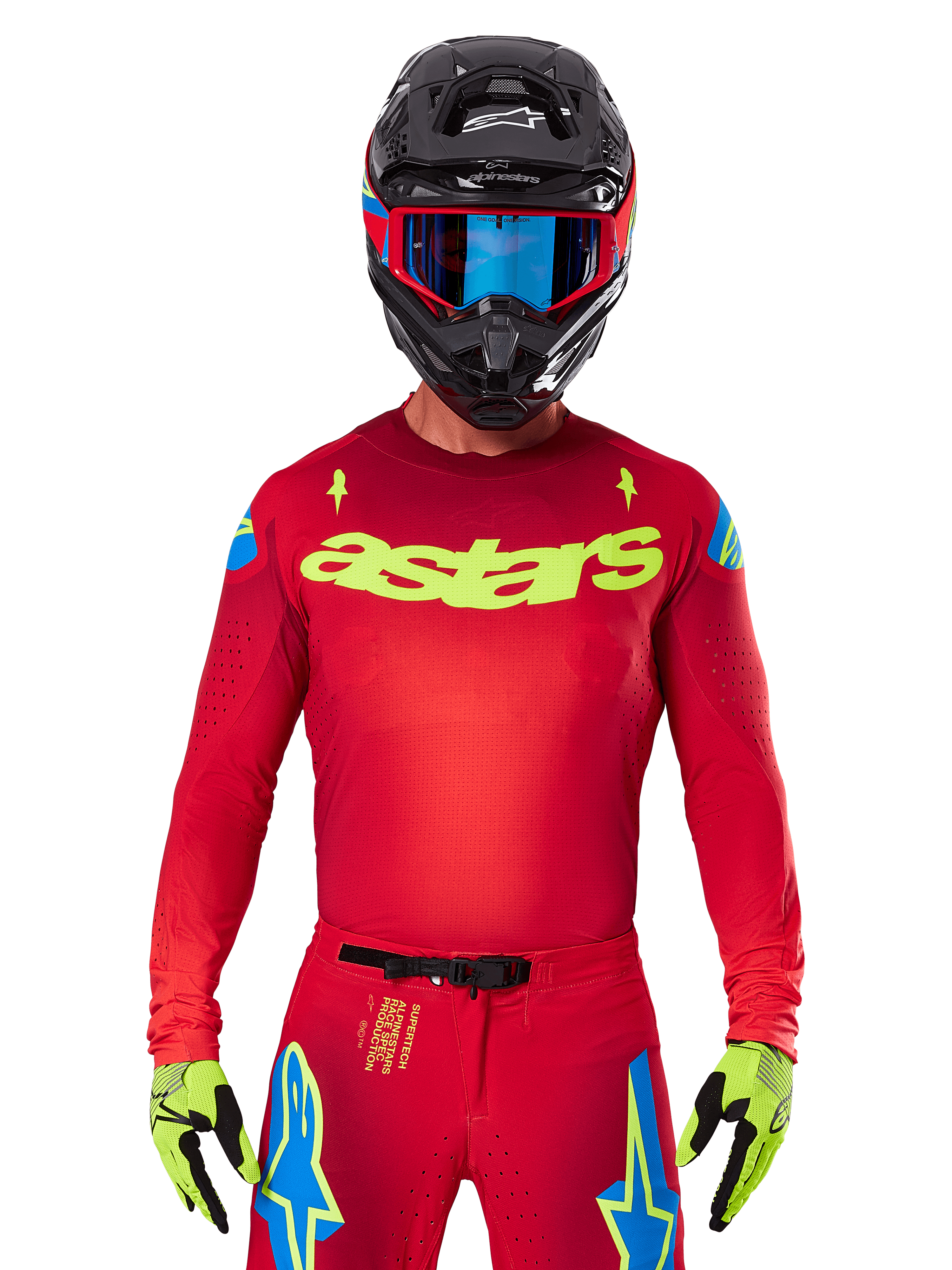 Alpinestars 2025 Supertech Maker Jersey in leuchtendem Rot und Gelb Fluo, mit gelbem „astars“-Branding auf der Brust und blauen Stern-Designs an den Schultern, getragen mit passender Hose, schwarzem Helm, blauer Brille und gelben Handschuhen, professionelle Motocross-Rennbekleidung
