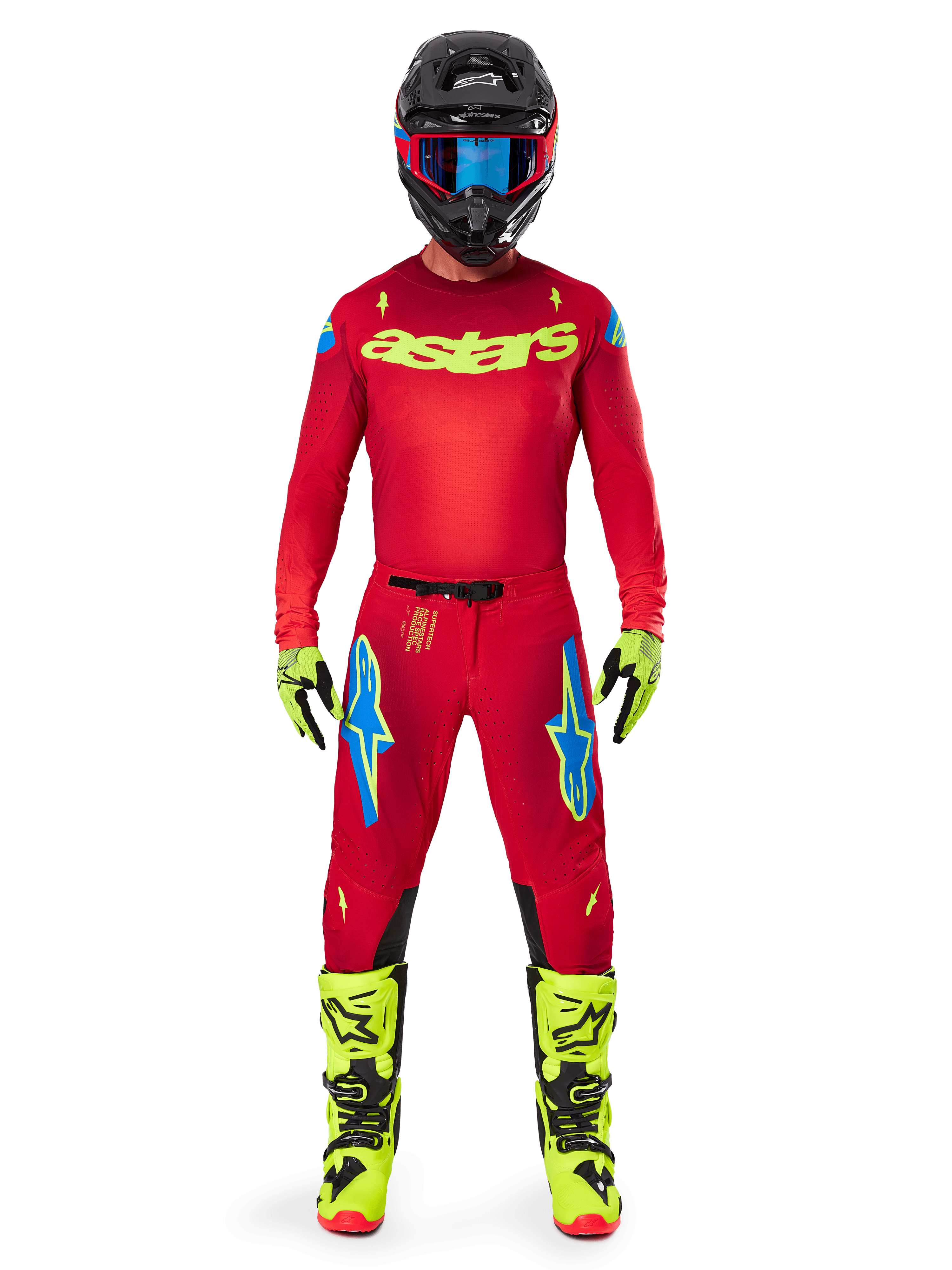 Motocross-Fahrer im kompletten Alpinestars 2025 Supertech Maker Gear Set, hellrotes Trikot mit neongelbem 'astars'-Branding, passende rote Hose mit blauen Akzenten, schwarzer Helm mit blauer Brille, leuchtend neongelbe Stiefel und Handschuhe, farblich abgestimmtes Outfit für den Offroad-Rennsport