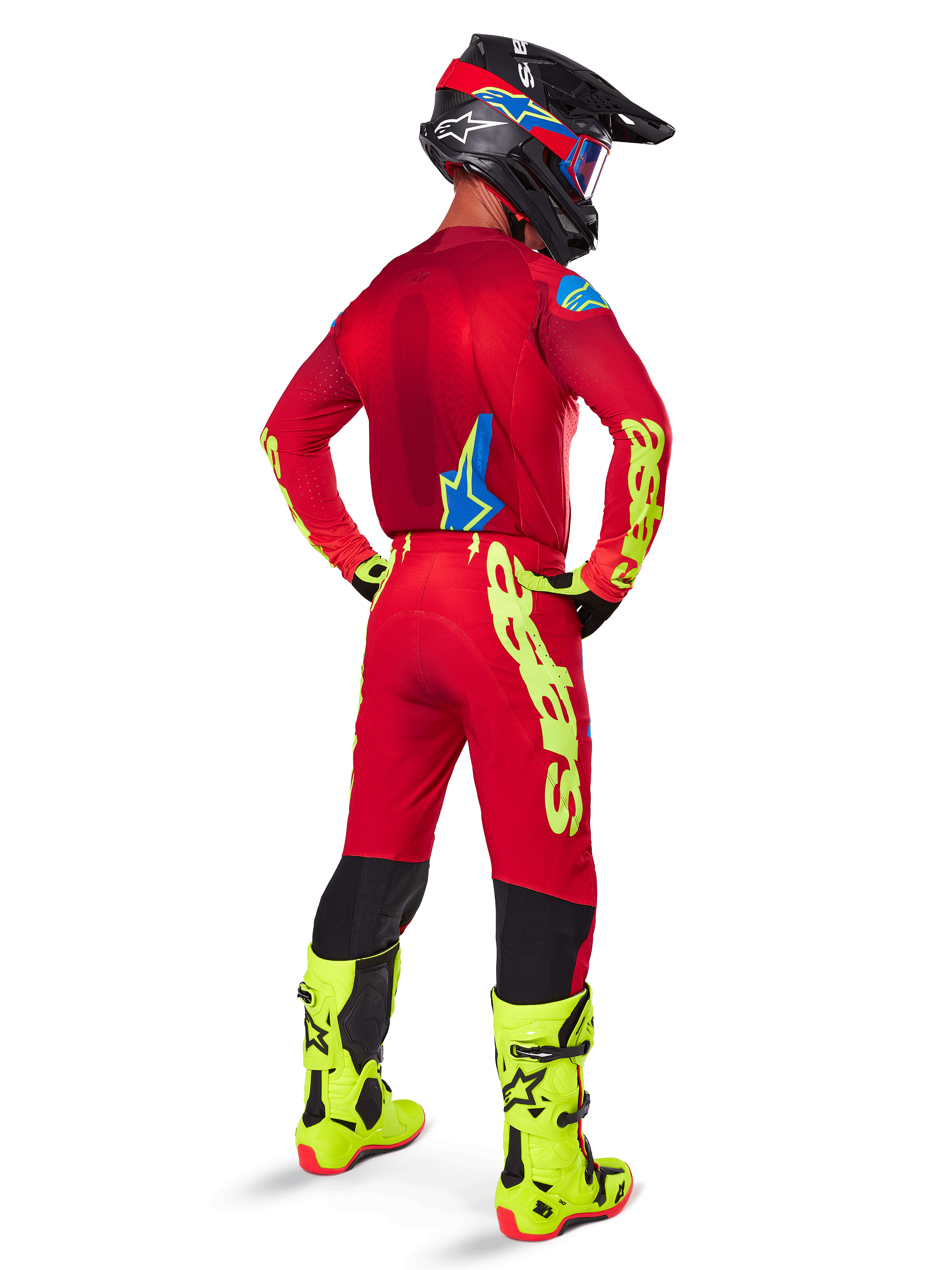 Motocross-Fahrer in der Rückansicht mit dem Alpinestars 2025 Supertech Maker Gear Set, leuchtend rotes Trikot mit neongelbem Branding, passende rote Hose mit gelben Akzenten, schwarzer Helm mit roten und blauen Details, neongelbe Stiefel, abgestimmtes professionelles Rennoutfit für Offroad-Performance.