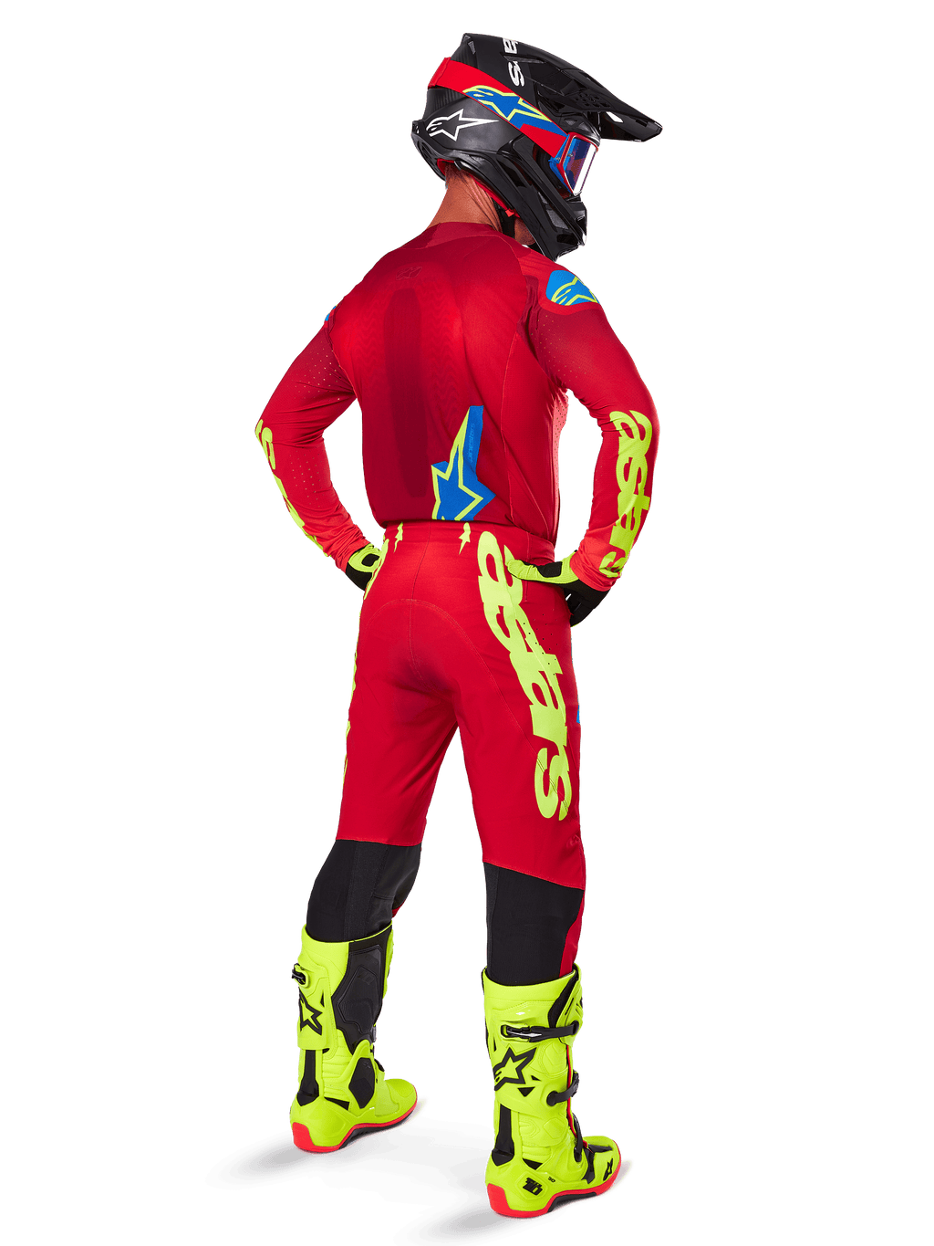 Motocross-Fahrer in der Rückansicht, trägt das Alpinestars 2025 Supertech Maker Trikot in Hellrot und Gelb Fluo, dazu passende Hose mit gelbem Branding, neongelbe Stiefel und einen schwarz-roten Helm, koordiniertes Outfit für den Profi-Offroad-Rennsport
