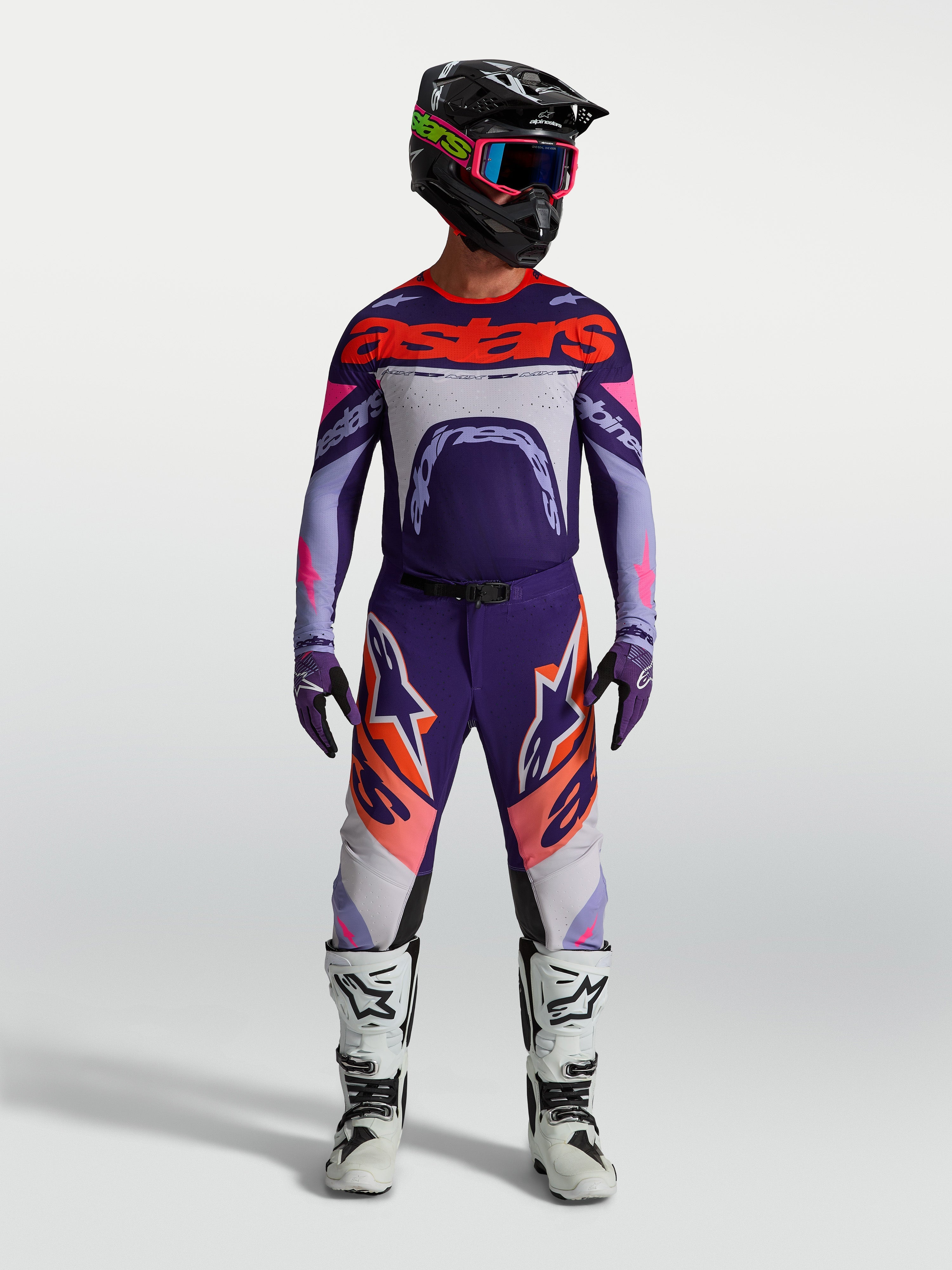 Alpinestars Supertech Dyna Trikot, Motocross-Renntrikot für Herren, Lila und Pink Fluo, athletische Passform, getragen von einem Fahrer mit Helm und Stiefeln.