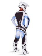 Alpinestars 2025 Techstar Melt Gear Set, Motocross-Fahrer in kompletter Rennausrüstung, weißes und hellblaues Trikot mit schwarzem Rückenpanel, passende Hose mit blauem Farbverlauf und schwarzen Akzenten, weißer Helm, weiß-schwarze Stiefel, abgestimmtes Outfit für Offroad-Rennen
