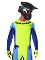2025 Techstar Melt Jersey, Motocross Racing Jersey, Yellow Fluo and Blue, featuring laser-cut ventilation and athletic race fit, worn by a rider with a black helmet and yellow fluo gloves