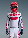 Alpinestars 2026 Racer Riway Trikot in Weiß-Blau-Rot, Motocross-Fahrer mit großem rotem „astars“-Logo auf der Brust, dunkelblaue Seiteneinsätze, passende weiß-rote Motocross-Hose, roter Helm mit weißer Brille, dunkelblaue Handschuhe, komplette Offroad-Rennausrüstung