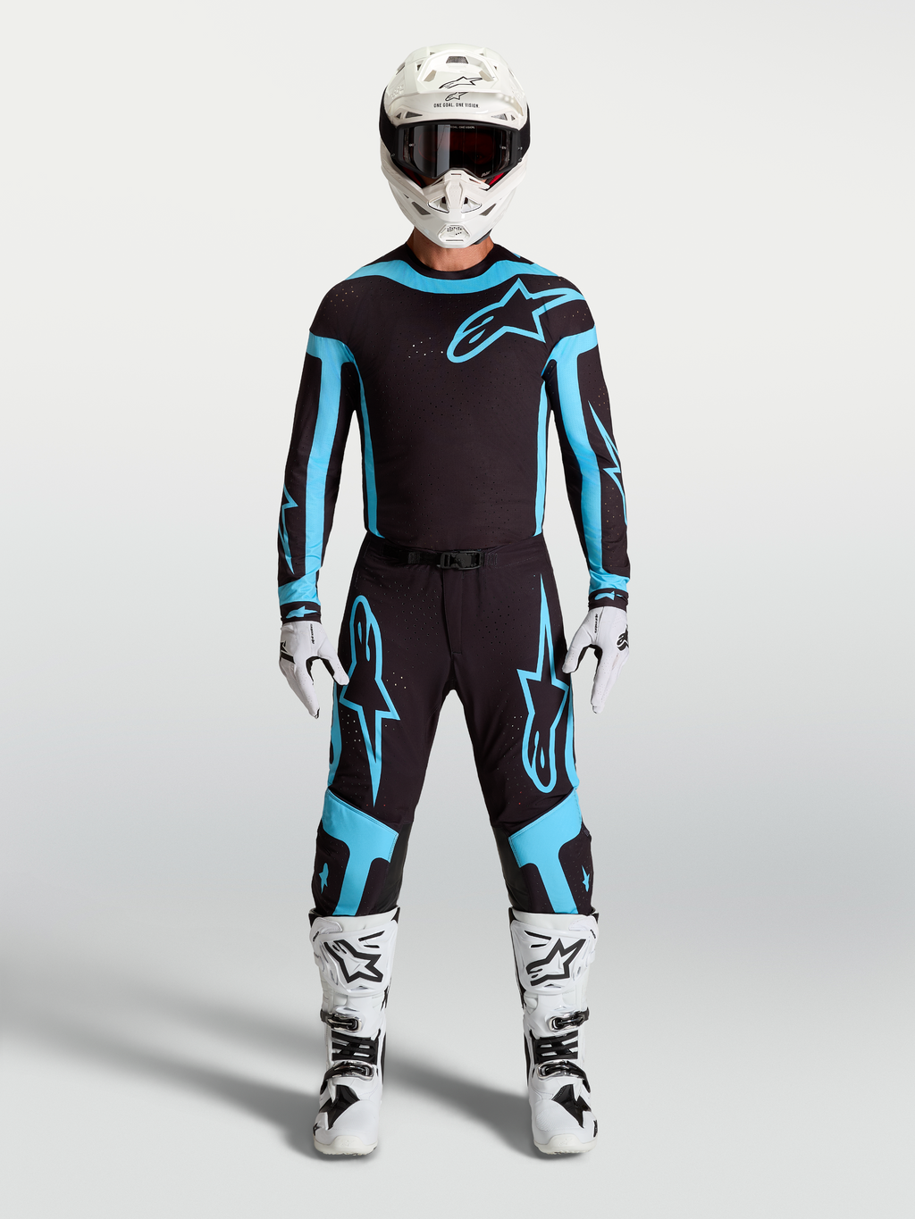 Alpinestars Supertech Vesta Trikot und Ausrüstungsset, Herren-Motocross-Outfit in Schwarz und Türkis, kombiniert mit weißen Stiefeln und Helm für professionelle Offroad-Performance.