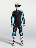 Alpinestars Supertech Vesta Trikot und Ausrüstungsset, Herren-Motocross-Outfit in Schwarz und Türkis, kombiniert mit weißen Stiefeln und Helm für professionelle Offroad-Performance.